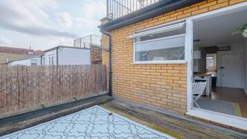 A residential property with a brick exterior, a wooden fence, and a small patio area.