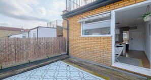 A residential property with a brick exterior, a wooden fence, and a small patio area.