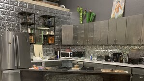 Een moderne keuken met een centraal eiland, roestvrijstalen apparatuur en een decoratieve spatwand.