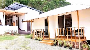 Una casa moderna con un porche cubierto, una pequeña escalera y plantas en macetas.