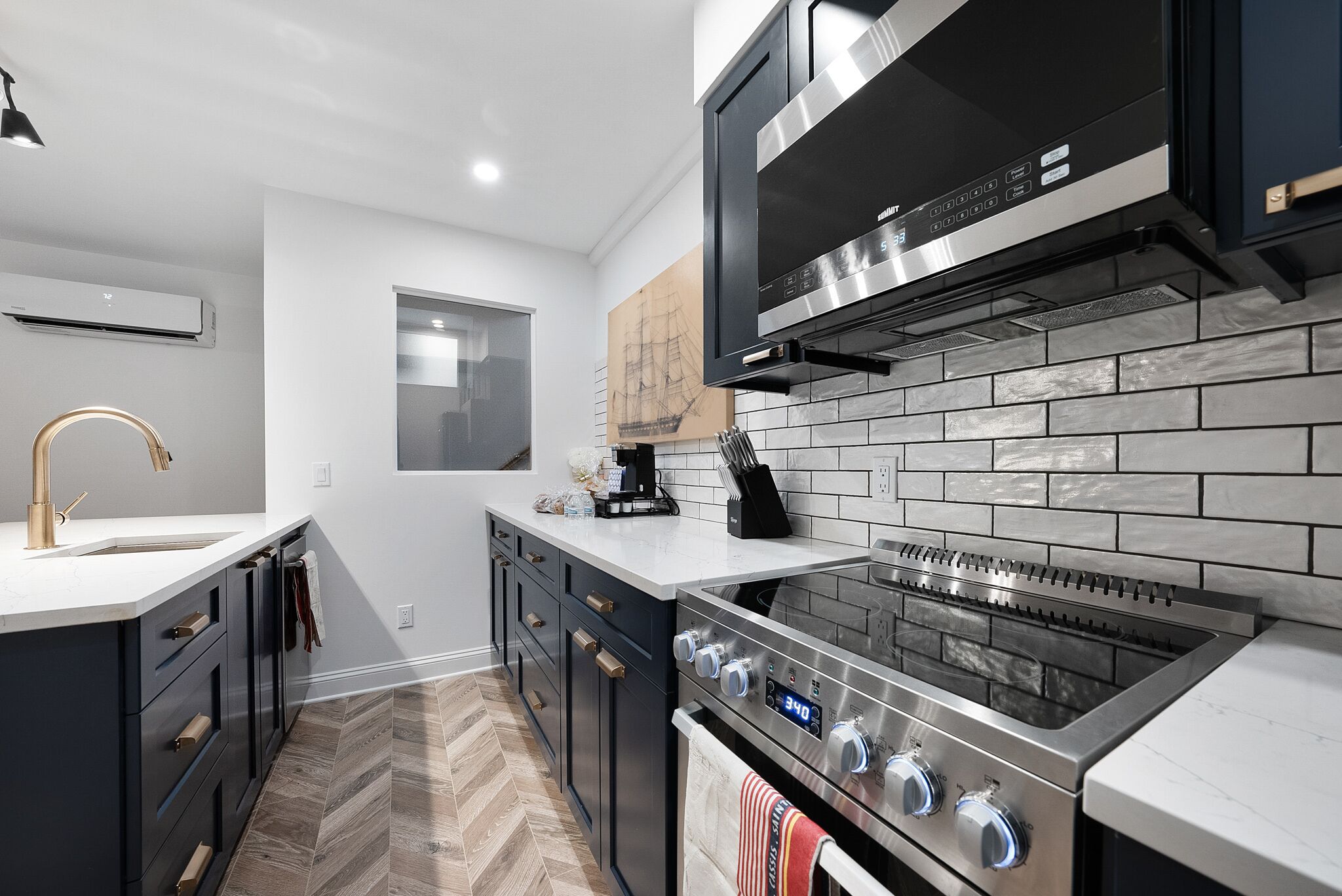 A modern kitchen with a built-in oven, a microwave, and a stainless steel range hood.