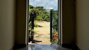 A hallway leading to a garden with a clear sky. - Grand Case Beach (Grand Case)
