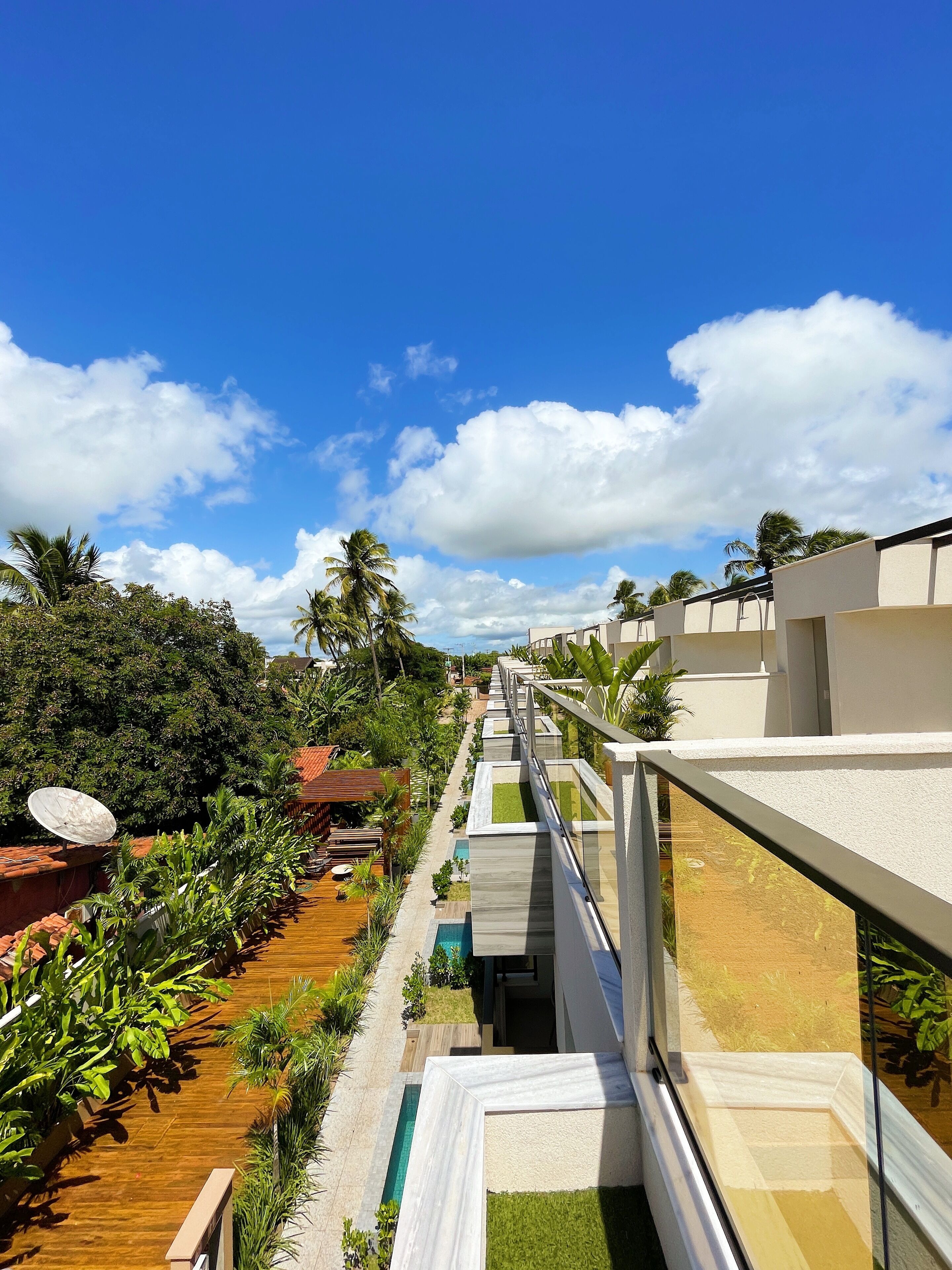 Een resort met een zwembad, terras en helder zicht op de lucht.