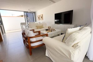 Relax in this stylish living room with a large flat-screen TV, comfortable sofa, and wooden coffee table.