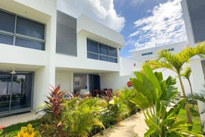 Stunning two-story building with a flat roof and symmetrical facade, featuring large windows and a covered outdoor area with seating.