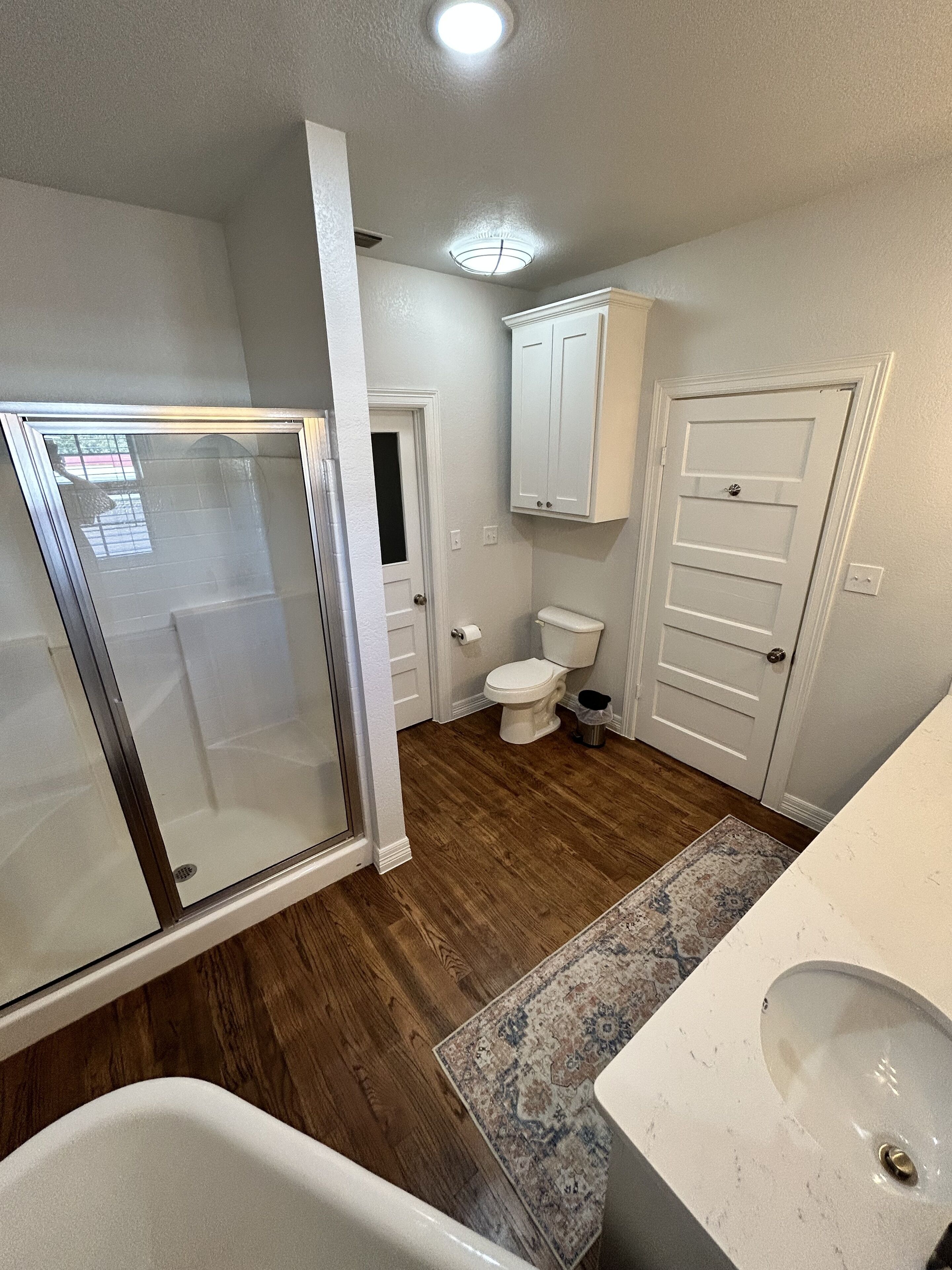 A bathroom with a shower, toilet, and sink.