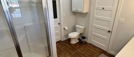 A bathroom with a shower, toilet, and sink.