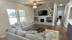 A living room with a sectional sofa, a TV, and a fireplace.