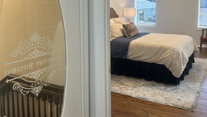 A bedroom with a bed, a nightstand, a lamp, and a ceiling fan.