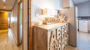Una cucina moderna con un'isola in legno, mobili a incasso e un frigorifero.