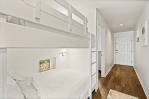 A bunk bed with a white headboard and a small decorative item on the wall.