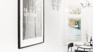 A framed quote on a wall in a bright, modern room with a dining area visible through an arched doorway. - Luxury Apartment - Wolverhampton (Wolverhampton)