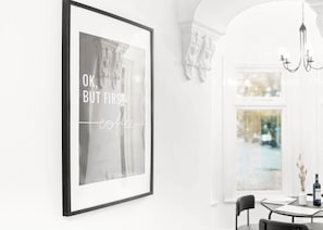 A framed quote on a wall in a bright, modern room with a dining area visible through an arched doorway. - Luxury Apartment - Wolverhampton (Wolverhampton)