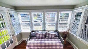 A bedroom with a bed, a window with blinds, and a view of the outside. - Beautifully remodeled single story cottage close to downtown Cincinnati! (Dayton)
