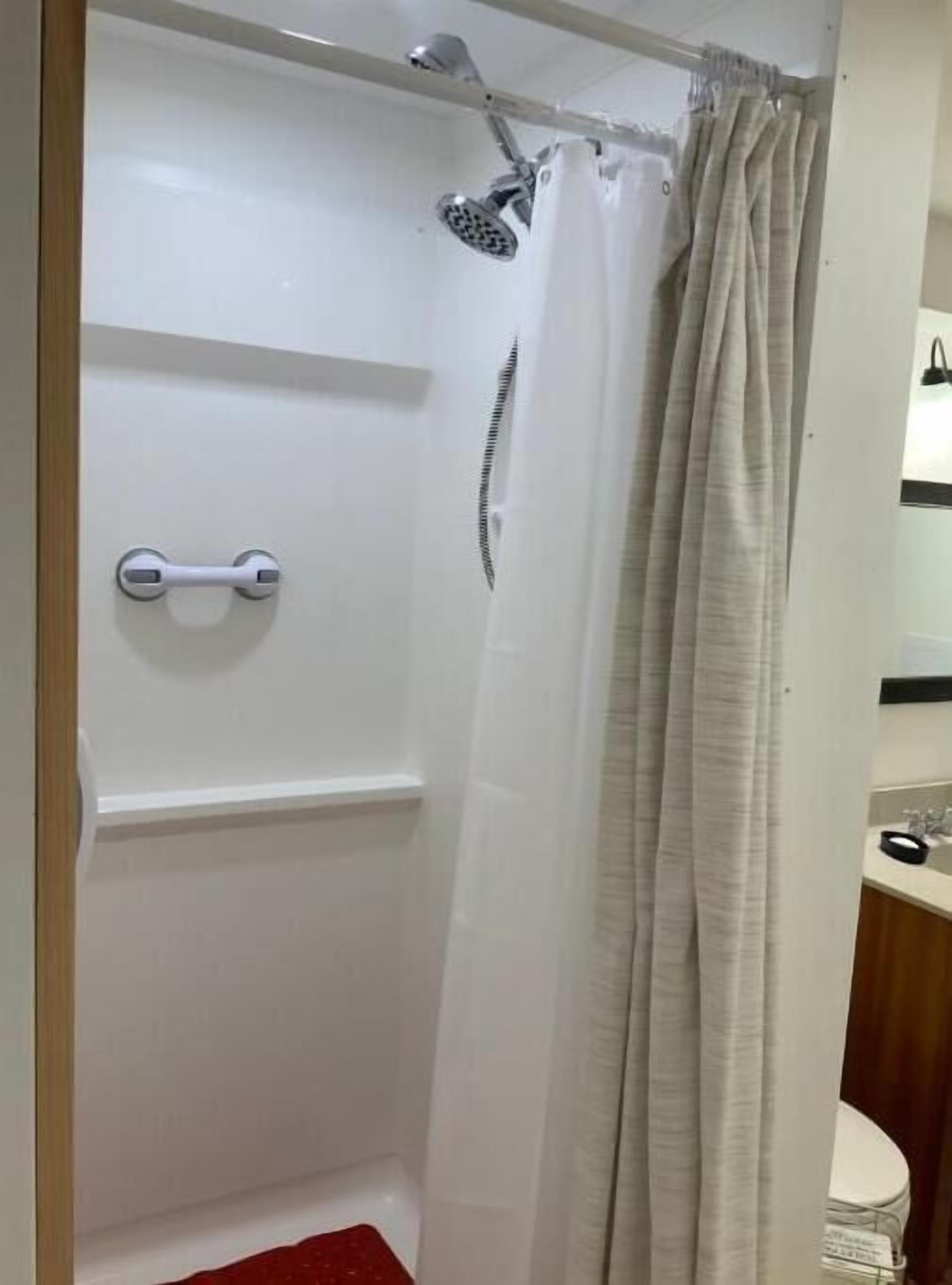 A bathroom with a shower, a toilet, and a sink.