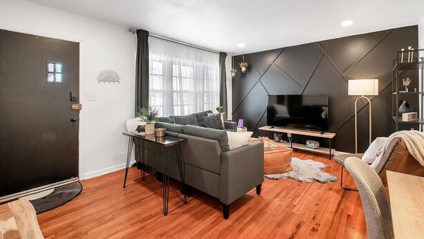A modern living room with a sofa, TV, and a coffee table. - Eclectic Escape - Cute and Cozy - King! (Wichita)