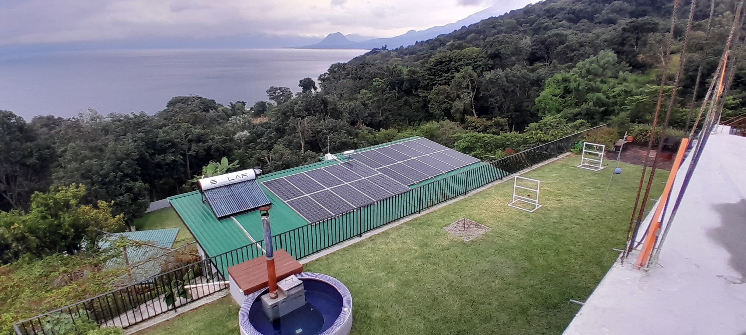 Ein Wohnhaus mit Solaranlage, Swimmingpool und Blick auf das Meer und die Berge.