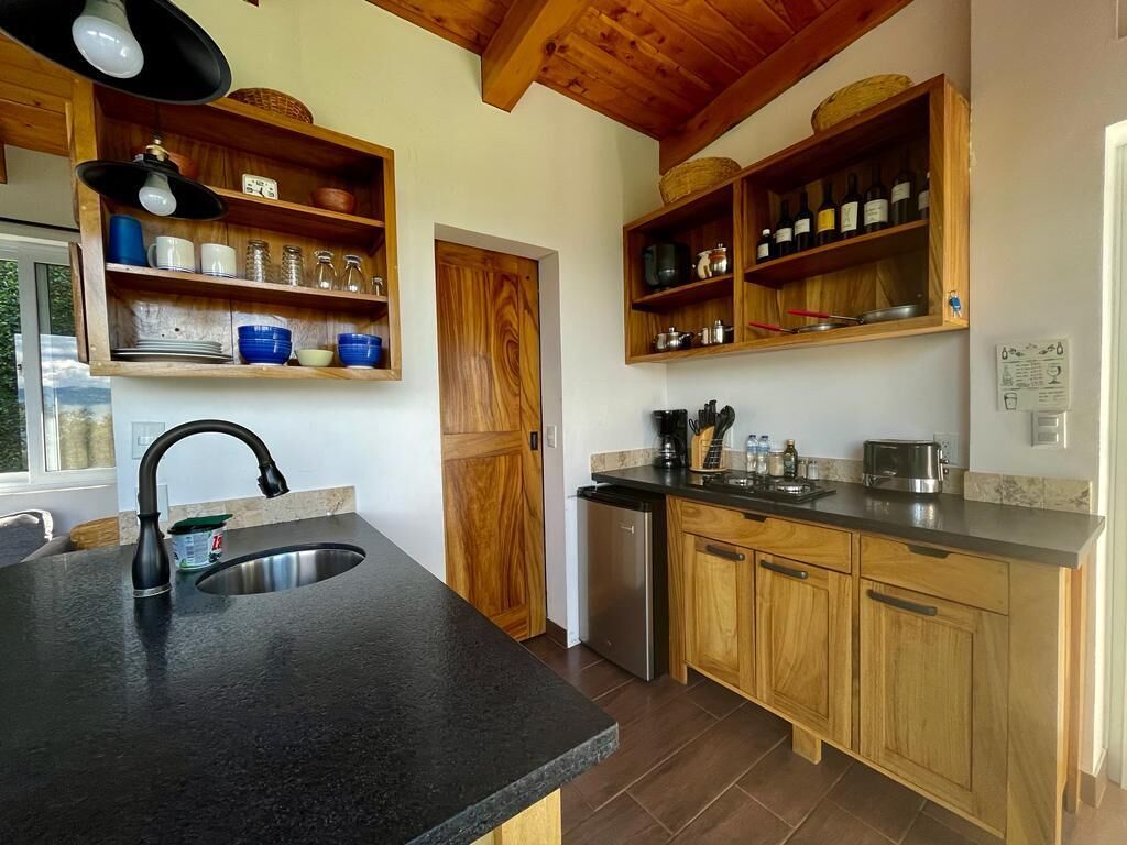 A kitchen with wooden cabinets, a stainless steel sink, and a built-in wine rack.