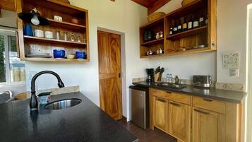 A kitchen with wooden cabinets, a stainless steel sink, and a built-in wine rack.