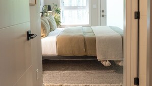 Un dormitorio con cama, ventana y puerta.