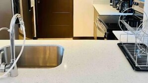 Een moderne keuken met roestvrijstalen apparatuur, een inbouwoven en een koffiezetapparaat.