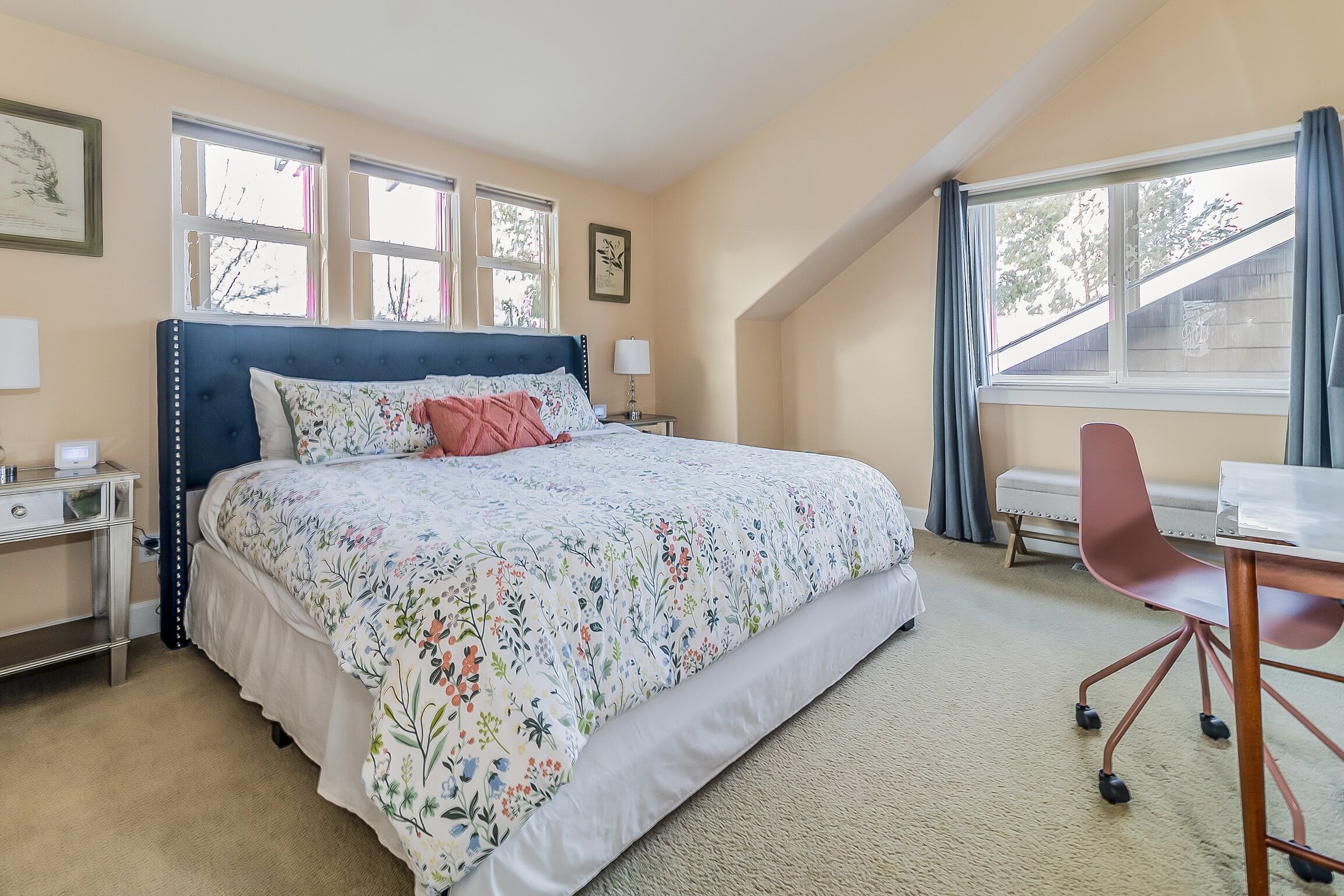 A bedroom with a large bed, a desk, and a chair.
