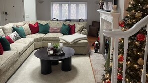 Een woonkamer met een modulaire bank, een salontafel en een kerstboom.