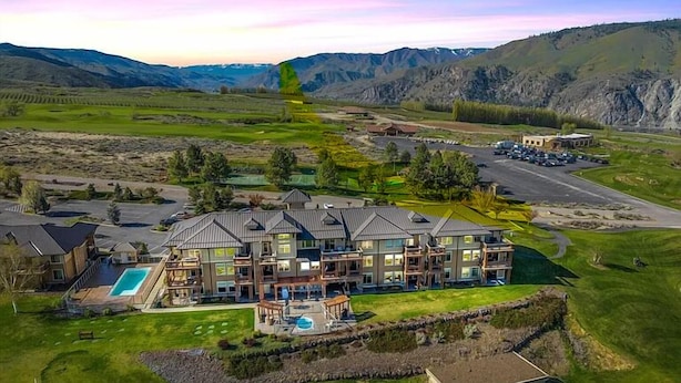 A large, multi-story building with a swimming pool and a covered patio area. - Desert Canyon Golf Resort (Orondo)