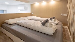 A hotel room with a large bed, a mirror, and a wooden wall. - X - Bella Apartment II Budapest (Budapest)