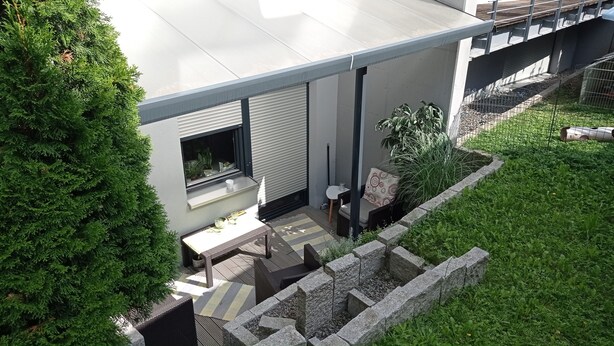 A modern outdoor patio area with a built-in fireplace, seating, and a stone retaining wall. - New comfort apartment. Basement, good for excursions, Europapark, Strasbourg (Ortenberg)