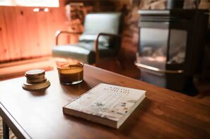 A wooden table with a book and a candle. - Hemlock Haven,Hot-tub,Private,30 min to Penn State (Mill Hall)