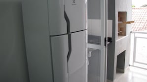 Een moderne keuken met een inbouwkoelkast en een glazen kast.