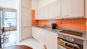 Eine moderne Küche mit hellen Schränken, einer Arbeitsplatte aus Granit und einem eingebauten Backofen.