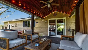 A covered patio area with wooden furniture, a ceiling fan, and string lights. - Après 4 All | Game Room, Hot Tub, Walkable (Ellicottville)