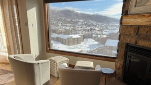 Un salón acogedor con un amplio ventanal que da a un pueblo nevado.