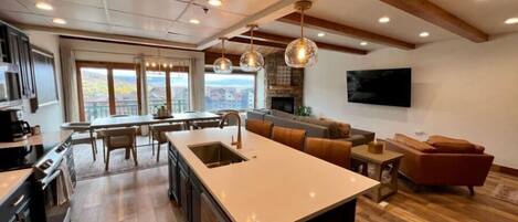 Una cocina moderna con una isla grande, suelo de madera y vistas a la ciudad.