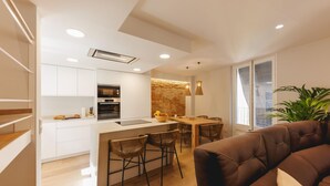 A modern apartment with a kitchen, dining area, and living room.