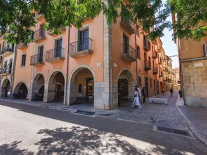 A row of traditional buildings with arched doorways and balconies.
