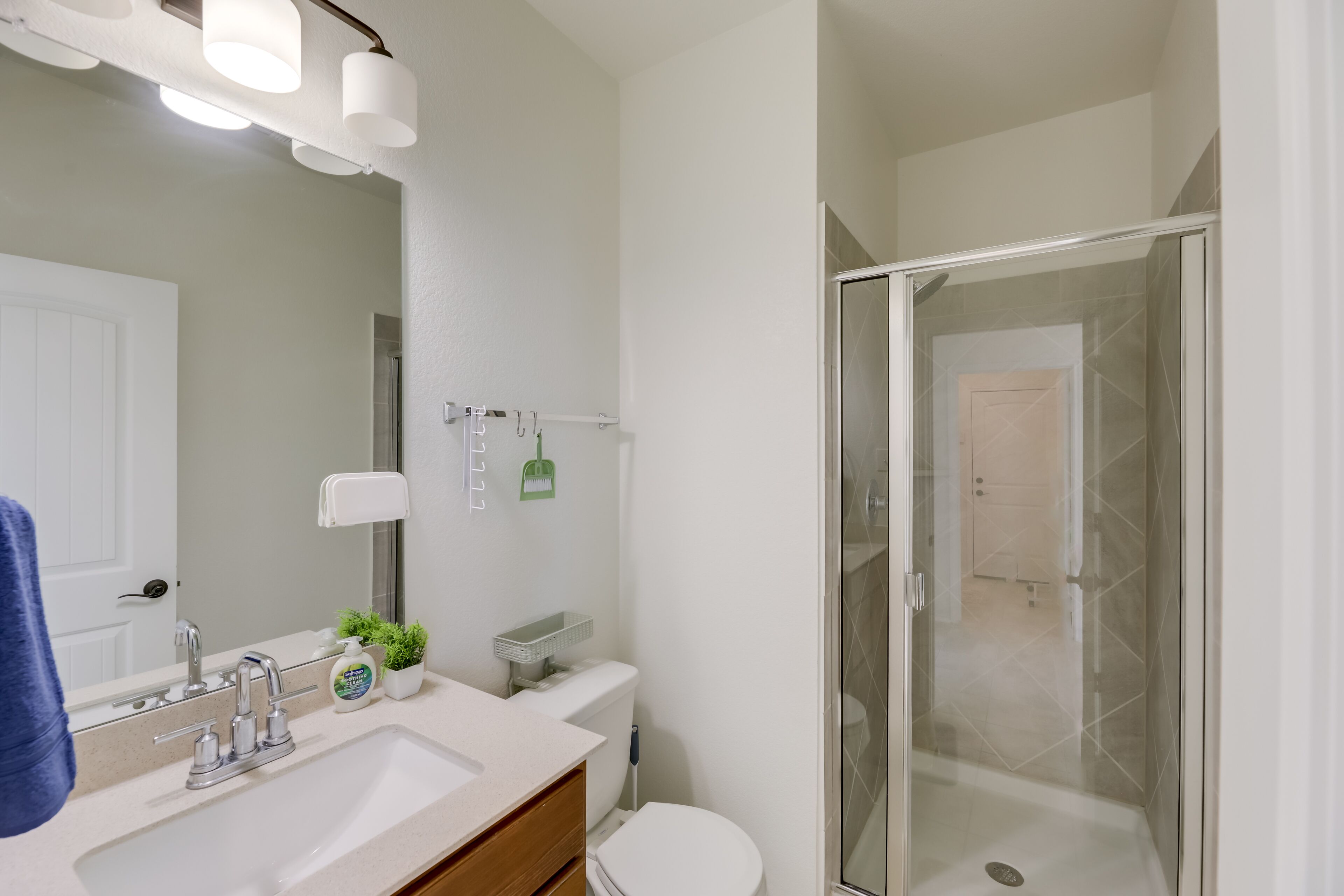 A modern bathroom with a sink, mirror, and toilet.