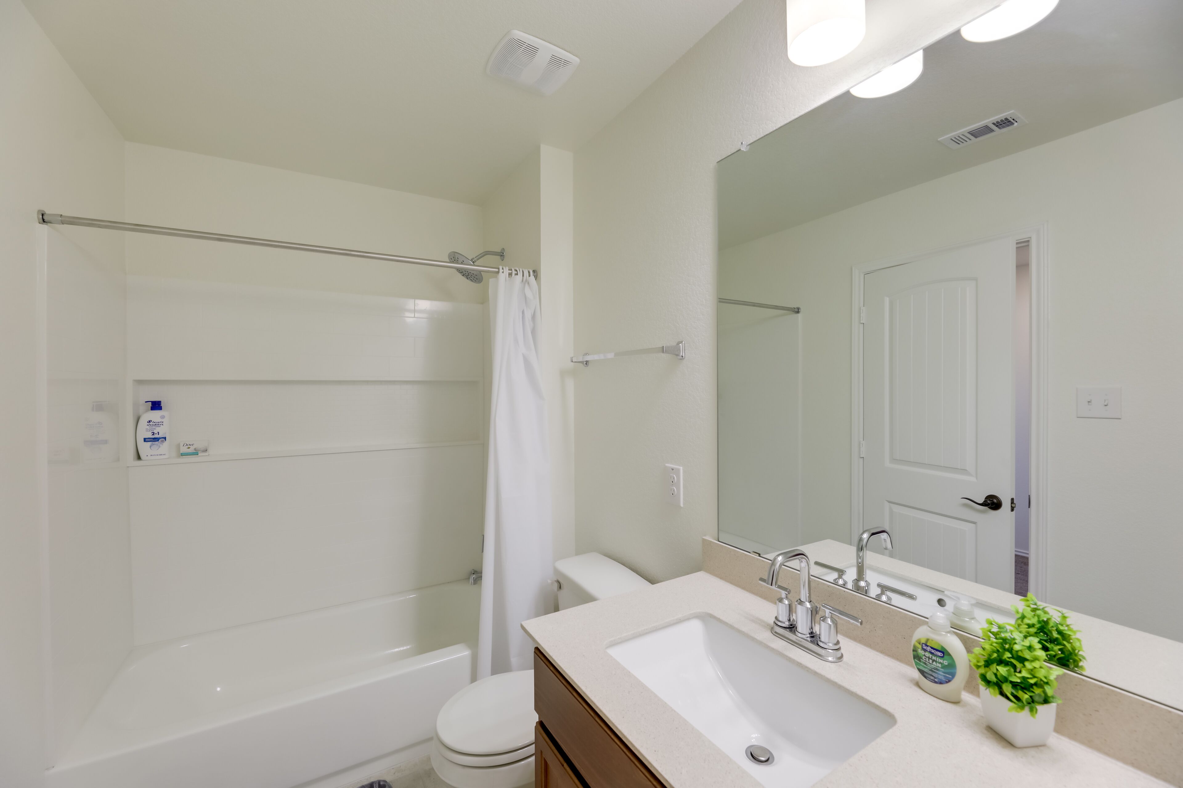 Une salle de bain moderne avec une baignoire, des toilettes, un lavabo et un grand miroir.