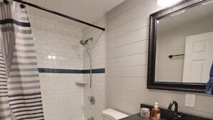 A bathroom with a shower, toilet, and sink.