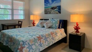 A bedroom with a bed, two bedside tables with lamps, a painting on the wall, and a window with blinds. - Jasmine-On the Harbour, Minutes from the Beach (Spanish Wells)