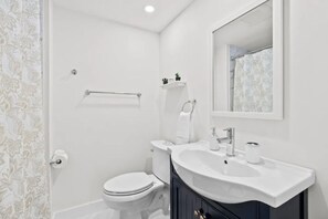 A modern bathroom with a toilet, sink, and shower.