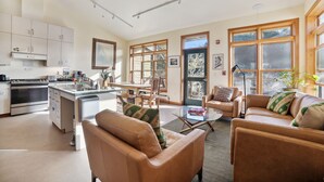 A spacious living area with a kitchen, a dining table, and a sofa. - Limantour Lodge-Laguna House-Perfect for Families! (Point Reyes Station)