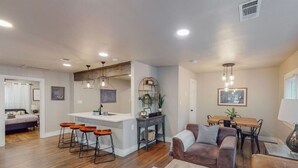Un salon moderne comprenant un canapé, une table basse et un coin repas avec une table et des chaises.