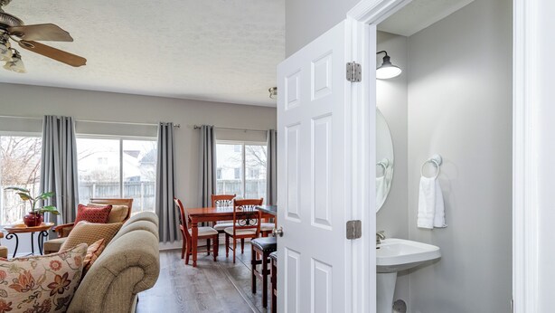 A living room with a sofa, dining table, and chairs, a ceiling fan, and a view of the outside. - Spacious 4BR - King Bed - Near I-70 (Dayton)