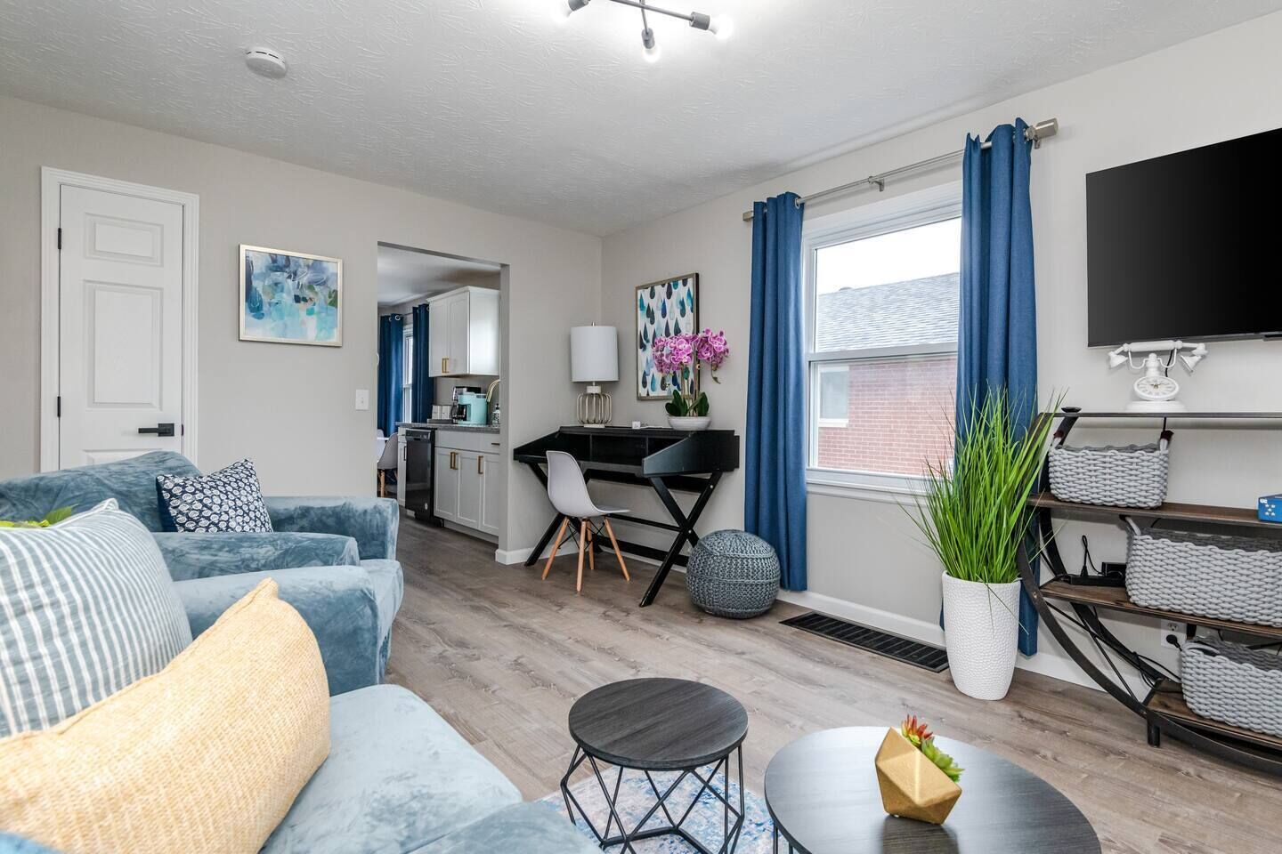 Een moderne woonkamer met een bank, salontafel en een eethoek met tafel en stoelen.