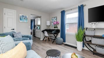 Een moderne woonkamer met een bank, salontafel en een eethoek met tafel en stoelen.