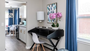 A modern kitchen with white cabinets, a black countertop, and a dining area with a white table and chairs. - Remodeled-Pet friendly-5 min to WPAFB and Downtown (Dayton)