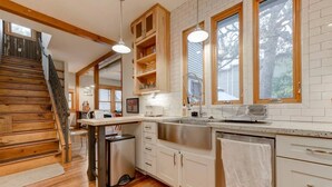 Una cocina moderna con armarios de madera, un lavamanos de acero inoxidable y un horno empotrado.